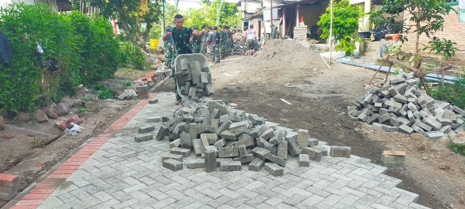 Satgas TMMD 125 Lanjutkan Pengerjaan Paving Jalan Menuju Jembatan di Siliragung