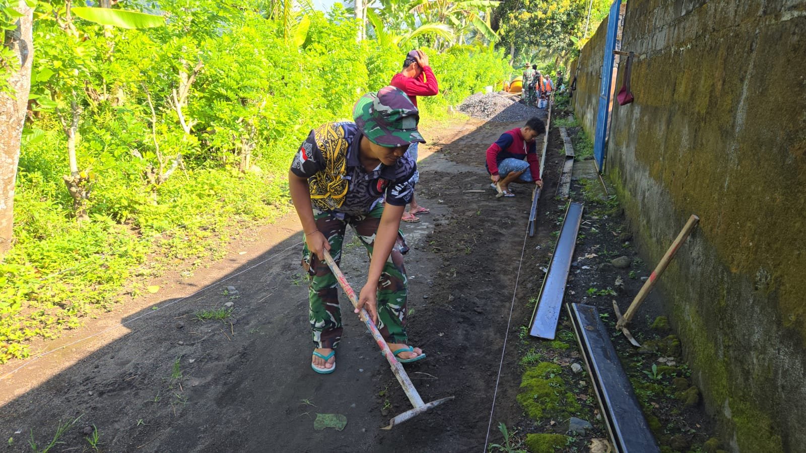 Anggota Satuan Tugas (Satgas) TNI Manunggal Membangun Desa (TMMD) ke-126 Kodim 0818/Malang-Batu dari Yonzipur 5/Abw terlihat bahu-membahu bersama warga setempat