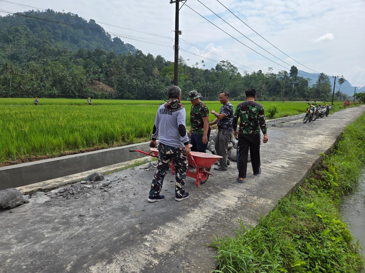 Personel Satuan Angkatan Laut (TNI AL) bersama Kodim 0818/Malang-Batu dan masyarakat setempat bahu-membahu melanjutkan pekerjaan saluran irigasi dalam program TMMD ke-126
