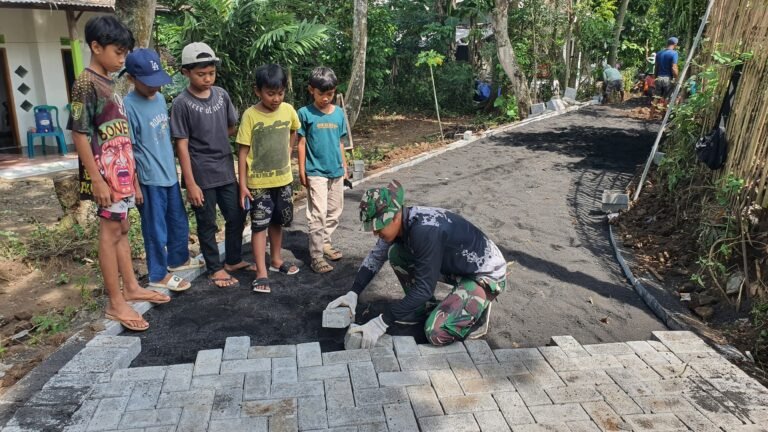 Anak-Anak Antusias Saksikan Pemasangan Paving TMMD Ke-128 di Desa Brabe.